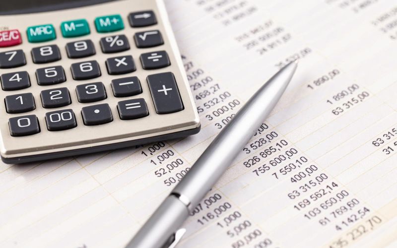 calculator and pen on spreadsheet calculating energy costs