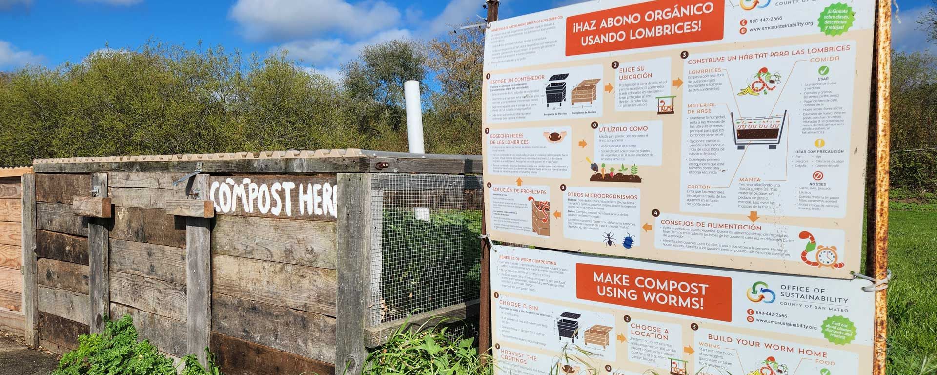 school garden compost bin with large instructional posters in Spanish and English
