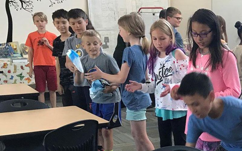 elementary students play recycling relay game in Solutions to Waste Schools Program