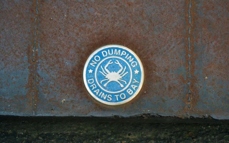 storm drain badge indicating no dumping - drains to bay