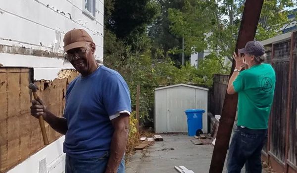two San Mateo County residents deconstructing the side of a home