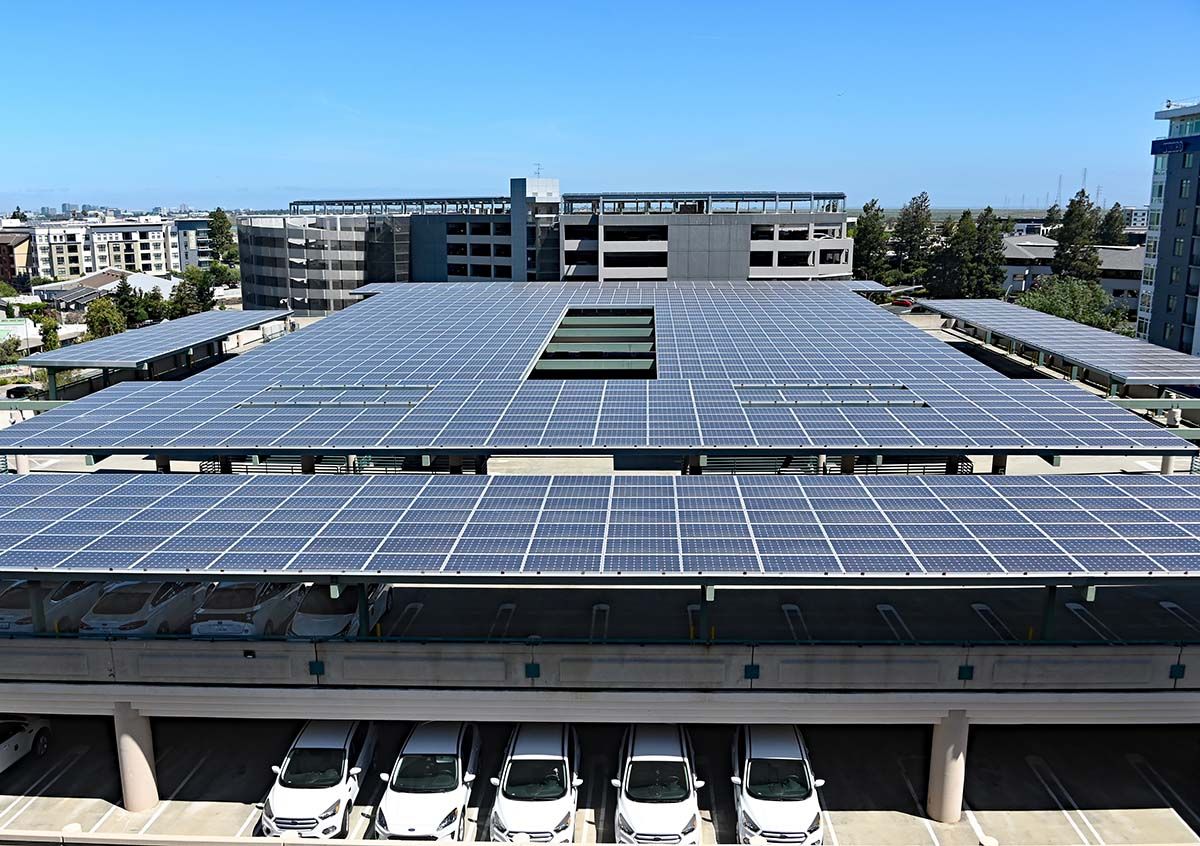public-parking-garage-top-floor-with-solar-panels-employee-parking-garage-in-background