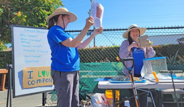 two instructors at San Mateo County composting workshop holding up composting materials