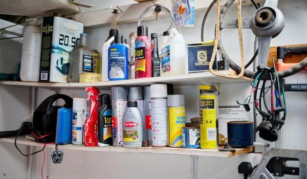 many containers of car maintenance products on garage shelves