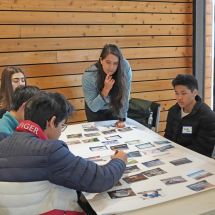 Youth Climate Ambassador students and mentor work on a poster project together