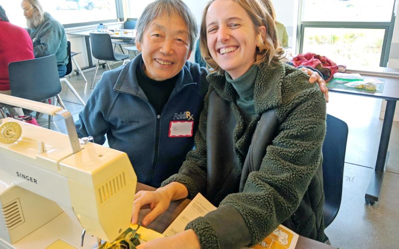 Fixit Clinic volunteer helps participant with sewing machine