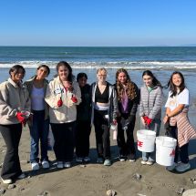 students picking up trash on the beach