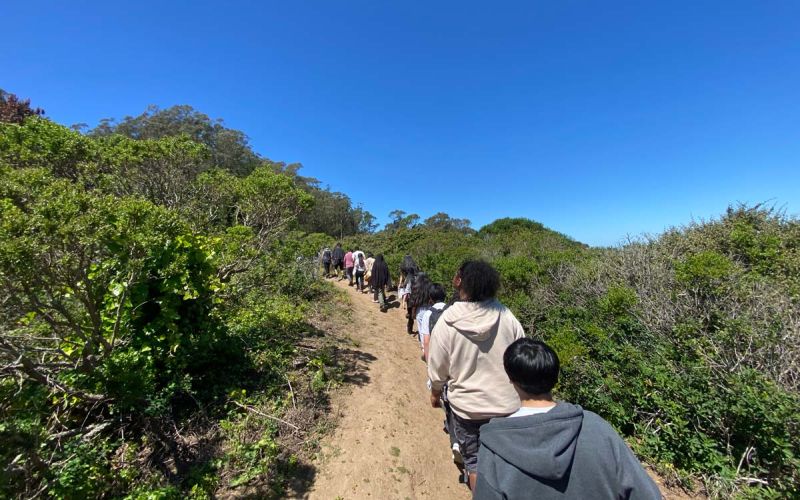 students walking mountaintop trail on field trip exploring biodiversity science