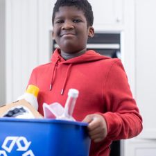youth carrying recycling bin