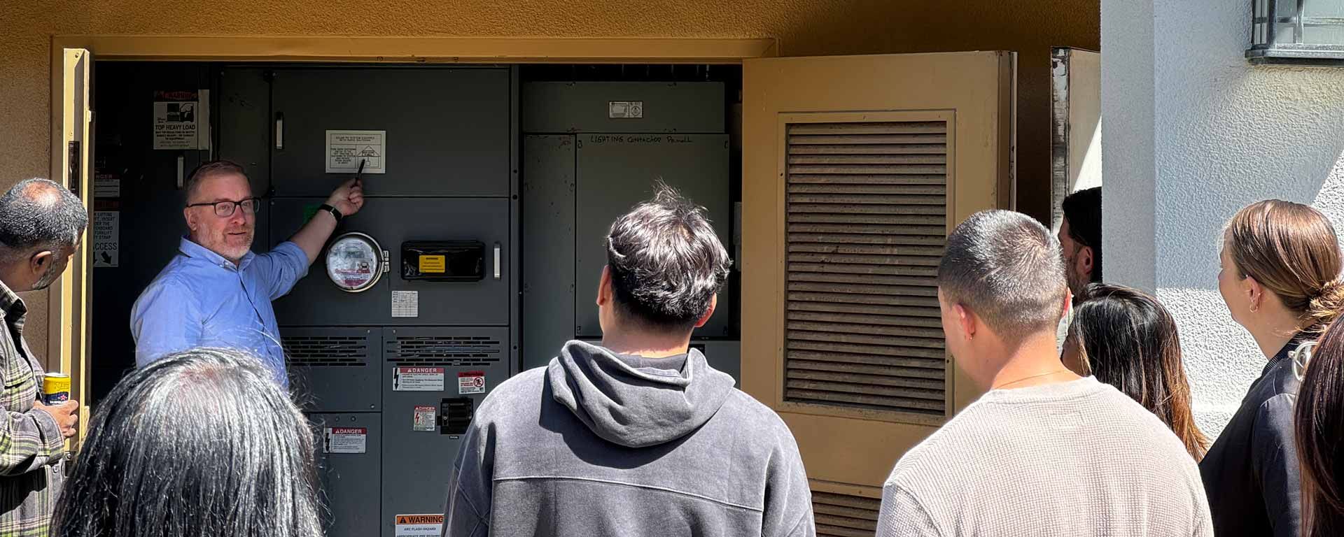 person pointing to an electrical panel in an all-electric home