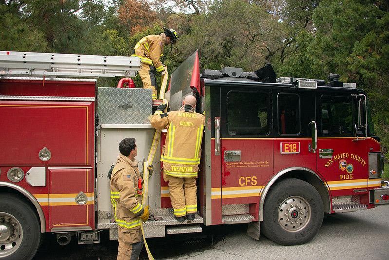 San Mateo County firefighters loading hose on fire engine