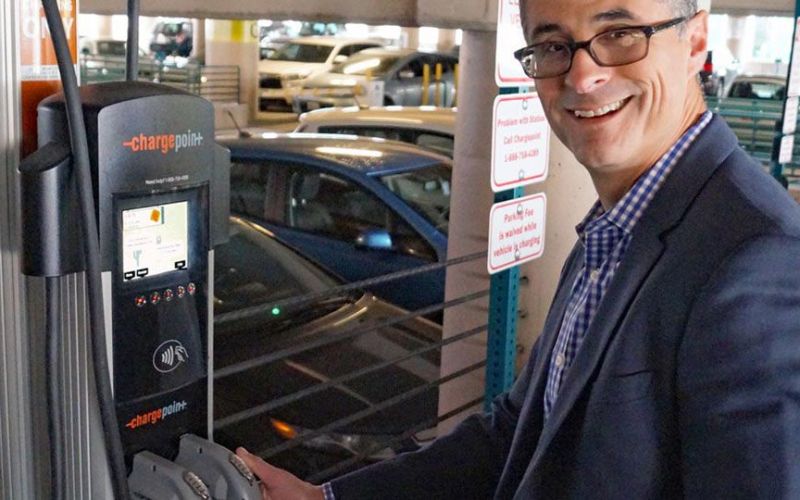 County employee charging an EV in county parking garage