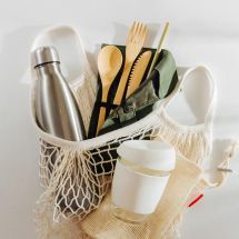 tote bag filled with a reusable water bottle, utensils, and coffee mug