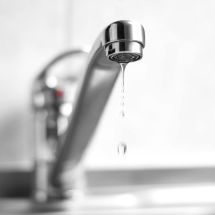 closeup of chrome kitchen water faucet dripping