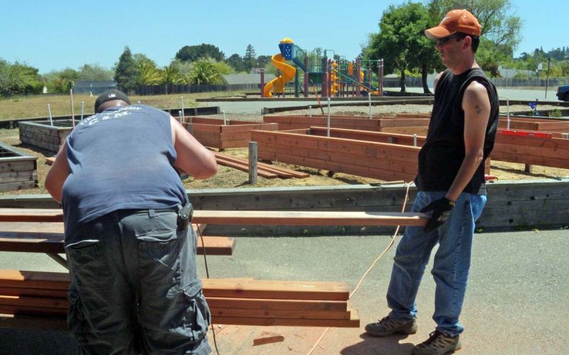 two men constructing school garden raised beds