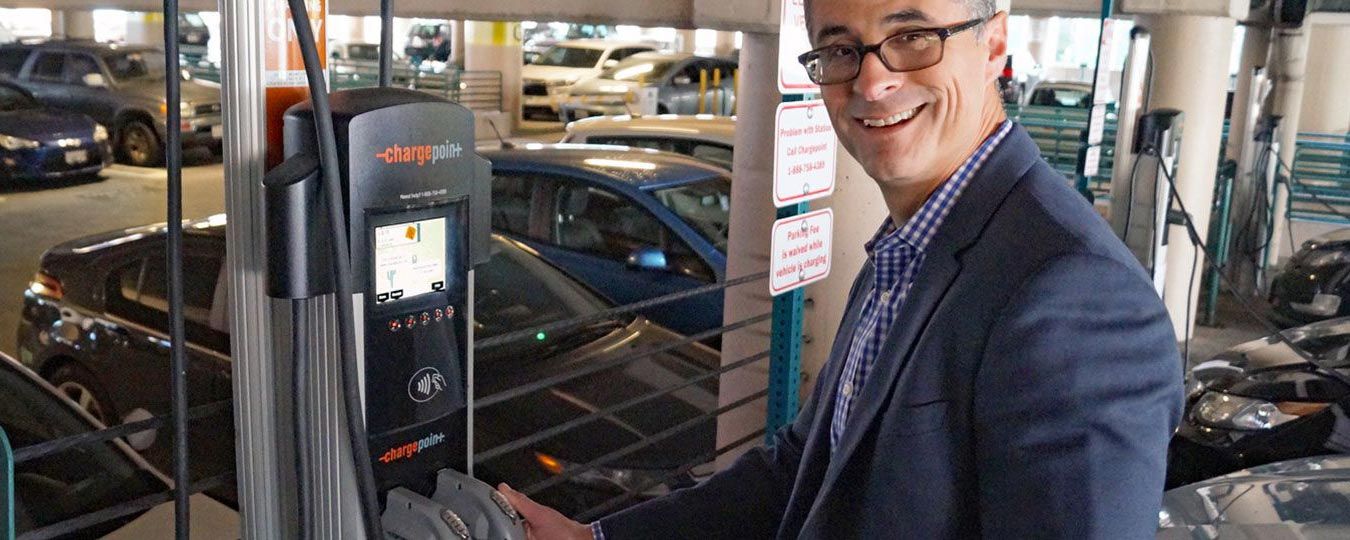 County employee charging an EV in county parking garage