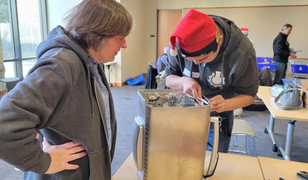 Fixit Clinic volunteer helps community member repair kitchen appliance