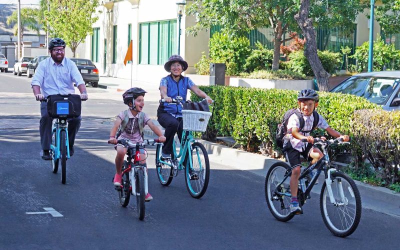 family riding bicycles downtown San Mateo