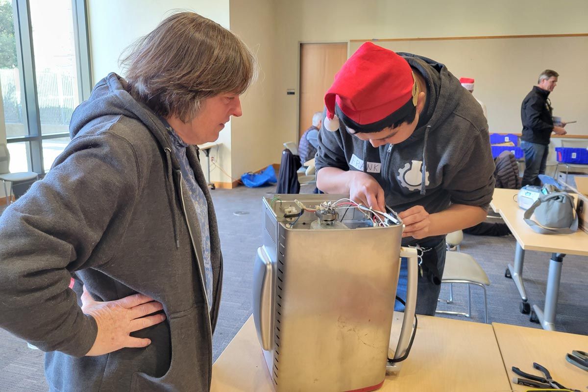 Fixit Clinic volunteer helps community member repair kitchen appliance