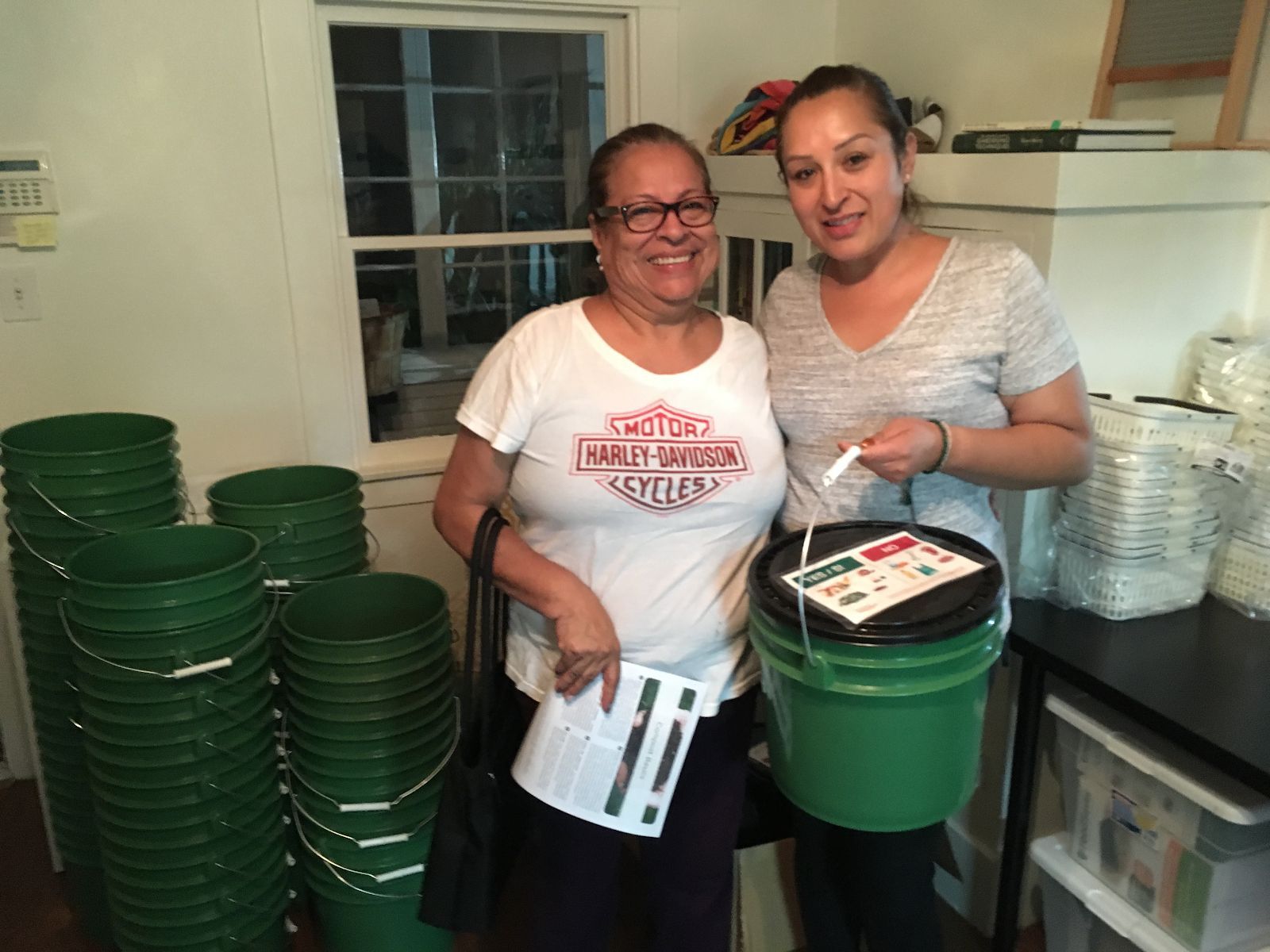 Community members collecting food scraps to compost using buckets provided by Fresh Approach