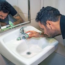 staff installing a faucet aerator to reduce water use
