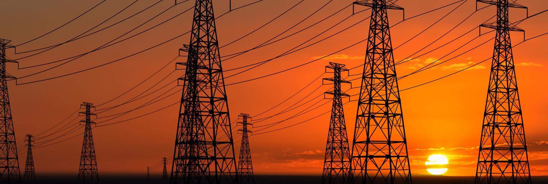 multiple power lines during bright orange sunset portrays extreme heat from climate change even for evening temperatures