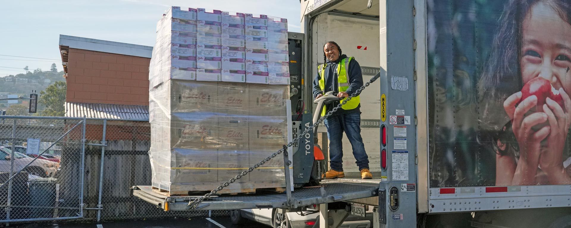 worker unloading semi-truck filled with food