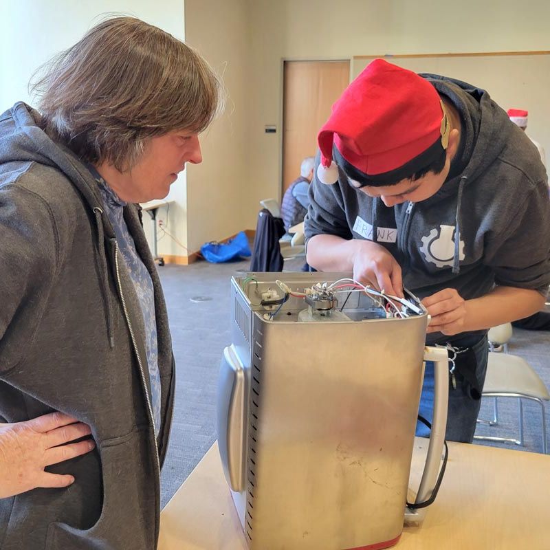 Fixit Clinic volunteer helps community member repair kitchen appliance