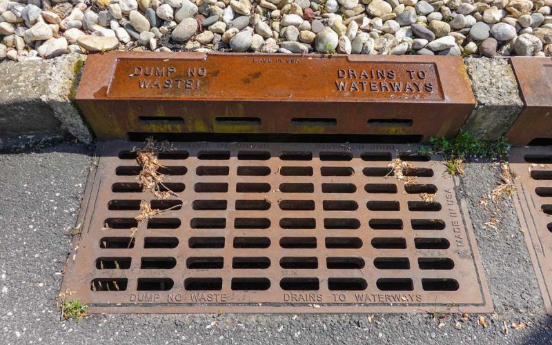 storm drain grate that reads no dumping - drains to waterways