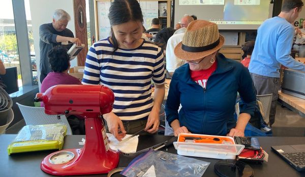 two women repairing stand mixer at San Mateo County Fixit Clinic