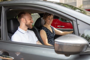 Smiling Man and Woman in a Gray Car