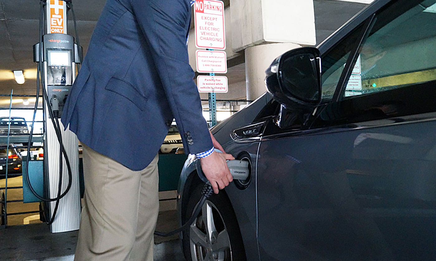 Man charging electric vehicle