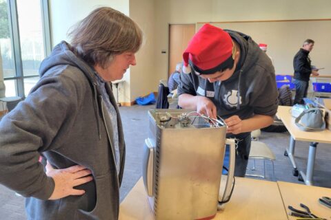 Fixit Clinic volunteer helps community member repair kitchen appliance