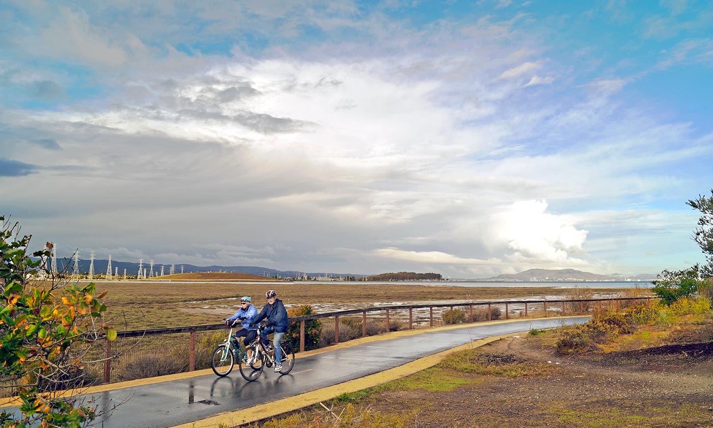 Couple riding bikes down bike path