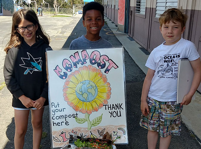 students with composting poster